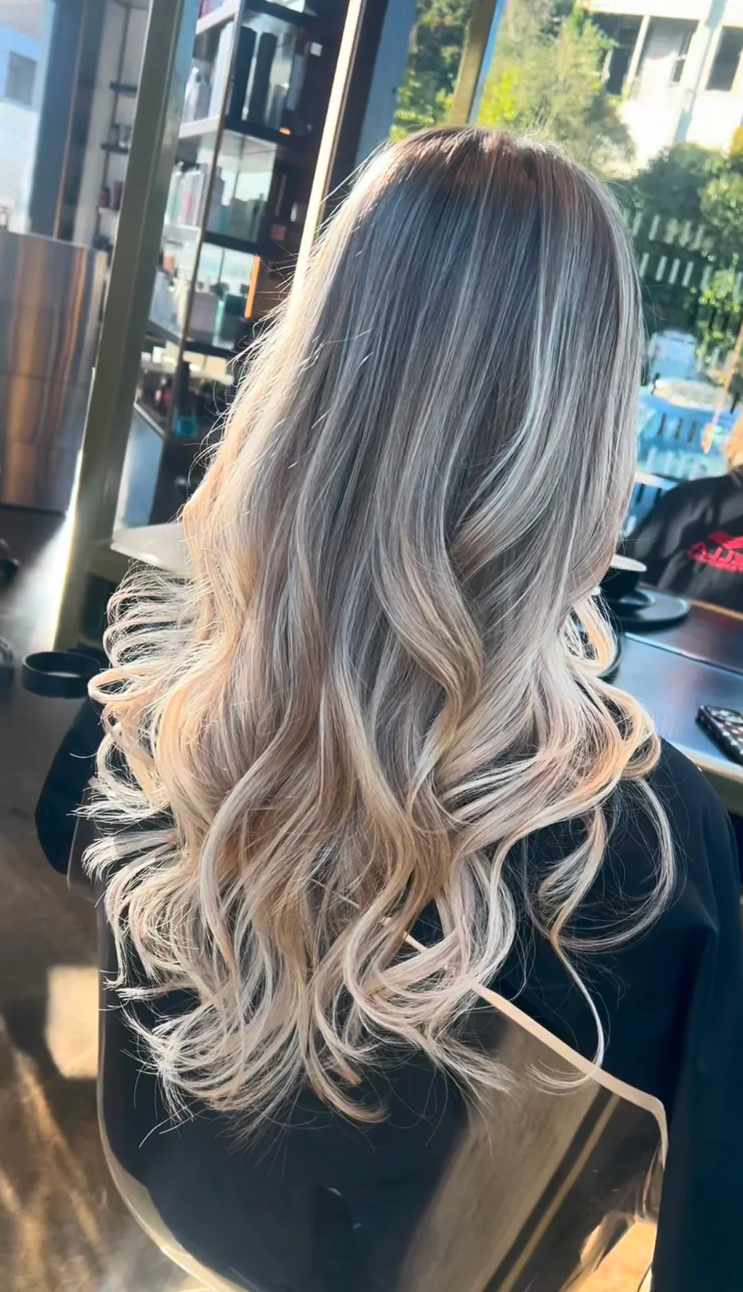 Long blonde tape-in extensions styled in soft waves